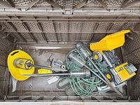 All items inside storage bin: pump, hose, solar lights, toy truck, footwear