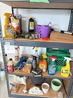 Three shelving levels with assorted garden chemicals, tools and accessories