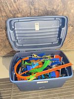 Closed blue tote containing Hot Wheels track parts