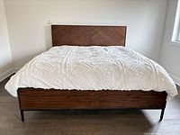 Full front view of king bed showing headboard, drawers, mattress