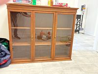 front view showing three glass doors and shelves