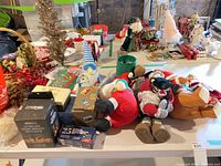 Wide view showing plush Santas, gnome, LED lights box, tree stand and assorted décor