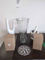 Group shot of all items: tall vase, bud vase, mortar & pestle, flower frog, two boxes