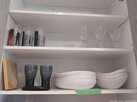 Cabinet shelves with Coca-Cola glasses, wine glasses, and Maxwell & Williams ramekins visible