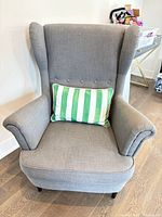 Front view of gray wingback chair with accent pillow