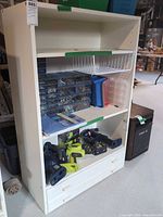 Front view of tall cabinet with drawers open showing shelves and accessories for scale