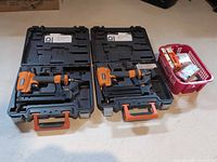 Two RIDGID pneumatic tools in cases with basket of fasteners
