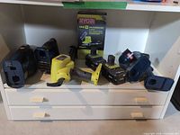 All Ryobi 18V ONE+ tools and two batteries on shelf