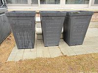 Front view of three charcoal plastic/resin planters