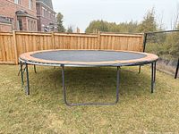 Full view of assembled 14 ft round trampoline on lawn