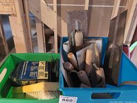 Two bins containing assorted trowels, hawk, float, brush and 3M pads