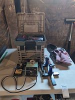 Overview of soldering station, third-hand holder, plastic tote and accessories on table