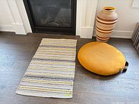 Vase, pouf and rug displayed together