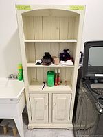 Front view of tall off-white cabinet beside washer