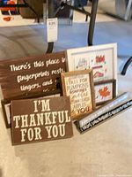 Group shot of all six wooden signs arranged on floor