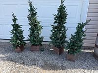 Four artificial porch trees in wooden planters displayed outdoors