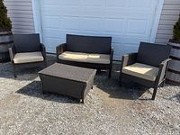 Full view of patio set placed outdoors in front of garage door