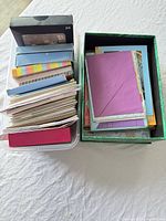 Two containers filled with various greeting cards and envelopes