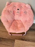 Front view of pink plush animal-face saucer chair