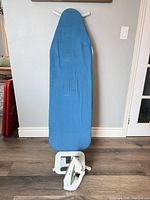Full view of ironing board with iron placed at base