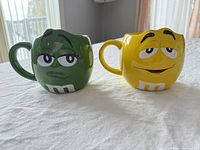 Green and Yellow M&M character mugs side by side