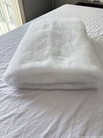 Folded white batting displayed on a surface