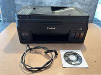 Canon Pixma G4210 printer front view with power cable and setup CD