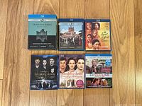 Overview of six Blu-ray cases including Downton Abbey S1–S2, The Secret Life of Bees, Twilight Parts 1 & 2, Eat Pray Love