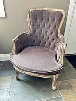 Front view of tufted purple French provincial armchair showing wood frame and cushion