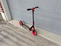 Full side view of black and red Globber kick scooter showing 205 mm wheels and foldable design