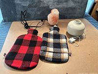 All four items: two plaid hot water bottles, Himalayan salt lamp, Saje diffuser with adapter