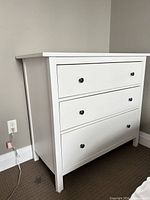 Front and side view of white 3-drawer dresser
