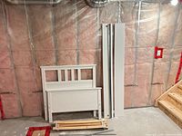 Headboard, footboard, side rails, slats laid out against wall