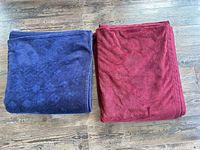 Folded navy queen and burgundy king blankets side by side