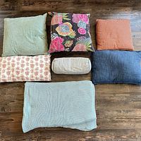 Seven textile pieces arranged on floor showing variety