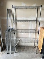 Assembled 5-shelf chrome wire shelving unit beside disassembled parts