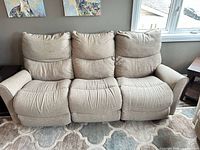 Front view of three-seat beige fabric power reclining sofa
