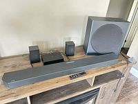 Front view of soundbar, subwoofer, surround speakers, wireless module and remote