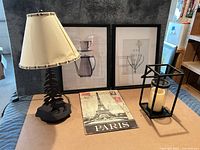 Group shot of lamp, two framed prints, lantern with candle, Paris plaque