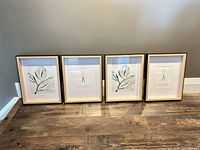 All four framed prints standing side-by-side on floor