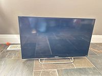 Front view of Sony 32" TV powered off on stand