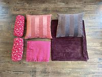 All six pieces laid out: two bolsters, two square pillows, two throws