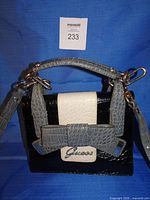 Front view of Guess handbag showing colors, bow, handle and logo