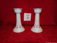 Front view of both porcelain candlesticks showing design and size card