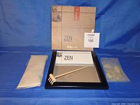 Complete Zen garden kit showing tray, rake, sand, stones and packaging sleeve