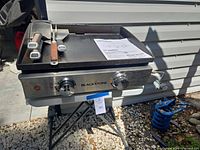 Front view of Blackstone 22-inch propane griddle with control knobs and utensils on cooktop