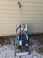 Full view of hose on wheeled reel cart with spray wand attached