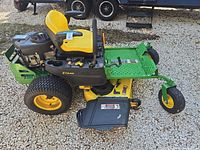 Left side view of John Deere Z355E mower showing deck, seat, wheels, discharge chute and overall condition