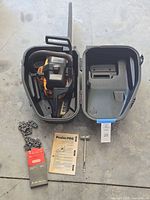 Chainsaw in open case with accessories arranged