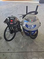 Both vacuums side by side with hoses and wands visible